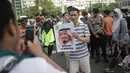Seorang pria berfoto sambil memegang poster bergambar Raja Salman, saat acara pawai suka cita menyambut kedatangan Raja Arab Saudi Salman bin Abdulaziz di kawasan Car Free Day, Bundaran HI, Jakarta, Minggu (26/2). (Liputan6.com/Faizal Fanani)