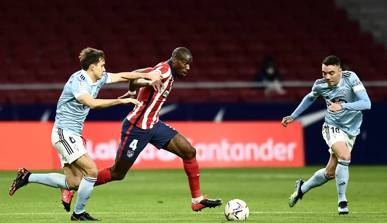 Gelandang Atletico Madrid, Geoffrey kondogbia membawa bola dari kawalan gelandang Celta Vigo, Denis Suarez pada pertandingan La Liga Spanyol di stadion Wanda Metropolitano di Madrid, Spanyol, Selasa (9/2/2021). Meski imbang, Atletico tetap bertengger di puncak klasemen. (AP Photo/Jose Breton)