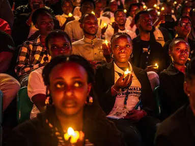 Para pemuda Rwanda memegang lilin saat mengambil bagian dalam acara mengheningkan cipta memperingati 30 tahun genosida Rwanda tahun 1994 di BK Arena, Kigali, 7 April 2024. (LUIS TATO/AFP)