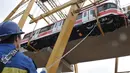 Proses perdana gerbong kereta layang ringan atau light rail transit (LRT) ke lintasan rel di Stasiun Harjamukti, Cibubur, Minggu (13/10/2019). Sebanyak satu rangkaian (trainset) yang terdiri dari 6 kereta (car) diangkat ke atas rel menggunakan Gantry Crane. (merdeka.com/Iqbal S Nugroho)