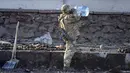 Tentara Ukraina minum air di dekat granat di sebuah jalan di Kyiv, Ukraina, Sabtu (26/2/2022). Pasukan Rusia menyerbu ke arah ibu kota Ukraina pada Sabtu (26/2), dan pertempuran jalanan pecah saat pejabat kota mendesak penduduk untuk berlindung. (AP Photo/Efrem Lukatsky)