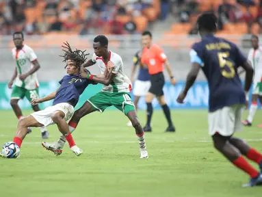 Pemain timnas Burkina Faso U-17 berebut bola dengan pemain timnas Prancis U-17, Souleymane Alio Prancis, Mathis Amougou pada laga pertama Grup E Piala Dunia U-17 2023 di Jakarta International Stadium, Jakarta, Minggu (12/11/2023) WIB. (Doc. LOC WCU17/BRY)