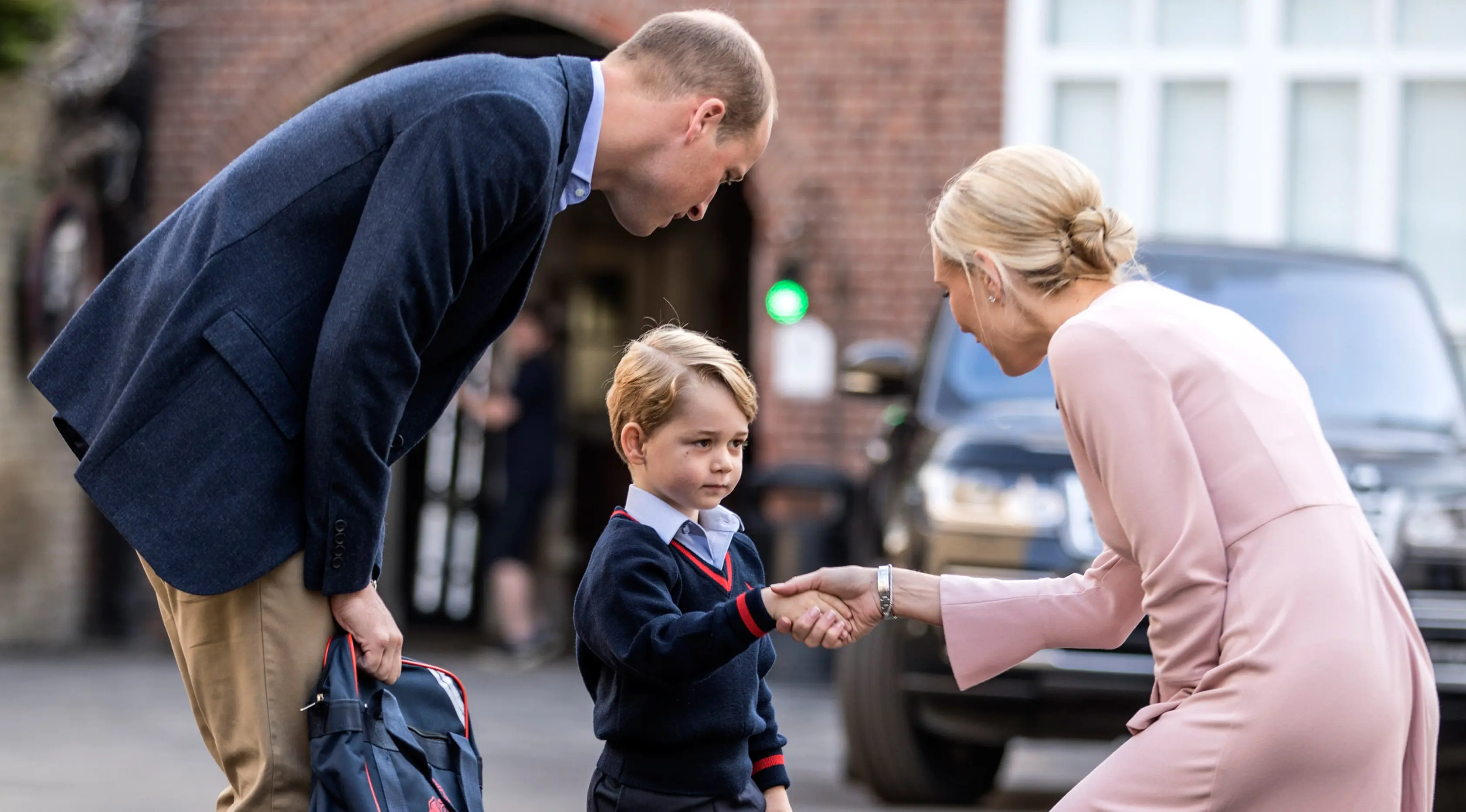 Pangeran George bersalaman dengan kepala sekolah Helen Haslem saat tiba Thomas's school di Battersea, London, Inggris (7/9). Pengeran Goerge tidak ditemani ibunya Kate Middleton yang sedang hamil. (Richard Pohle/Pool Photo via AP)