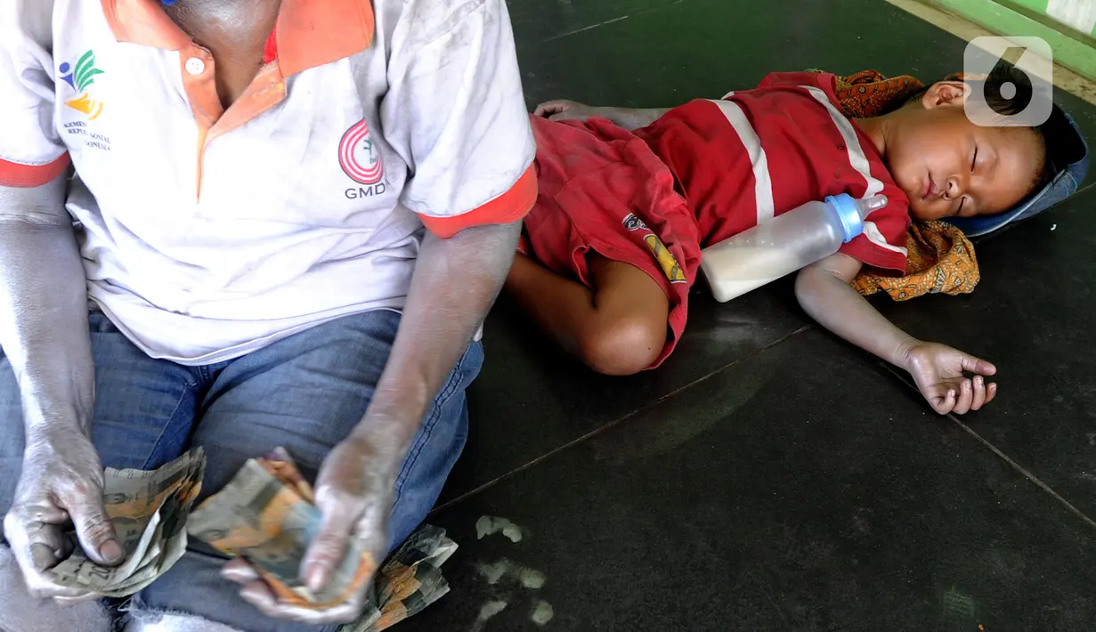 Rata-rata Rp 50 ribu hinga Rp 100 ribu diperoleh dari mengamen hingga jelang sore hari. “Yang penting dapat membeli susu buat Reihan dan makan sehari-hari”, tuturnya. (merdeka.com/Arie Basuki)