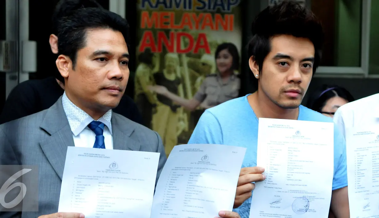 Martin Carter dan kuasa hukumnya menunjukkan surat usai keluar dari Sentra Pelayanan Kepolisian, Polda Metro Jaya, Jakarta, Rabu (19/8/2015). Ia melaporkan sejumlah penyanyi terkait pemutaran lagunya tanpa izin. (Liputan6.com/Panji Diksana)