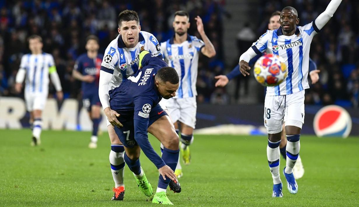 Pemain Real Sociedad, Igor Zubeldia, mengadang pemain Paris Saint-Germain, Kylian Mbappe, pada laga leg kedua babak 16 besar Liga Champions 2023/2024 di Stadion Reale Arena, Rabu (6/3/2024). Berkat hasil ini, PSG pun berhak melaju ke babak perempat final dengan kemenangan agregat 4-1. Pada laga leg pertama di Paris Februari lalu, PSG menang dengan skor 2-0. (AP Photo/Alvaro Barrientos)