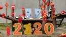 Anak-anak panda yang lahir pada tahun 2019 bermain di dekat dekorasi untuk menyambut Tahun Baru Imlek di tempat perlindungan Shenshuping di Cagar Alam Nasional Wolong, provinsi Sichuan, Jumat (20/1/2020). Imlek 2020 atau tahun baru Cina 2571 jatuh pada 25 Januari mendatang. (STR / AFP)