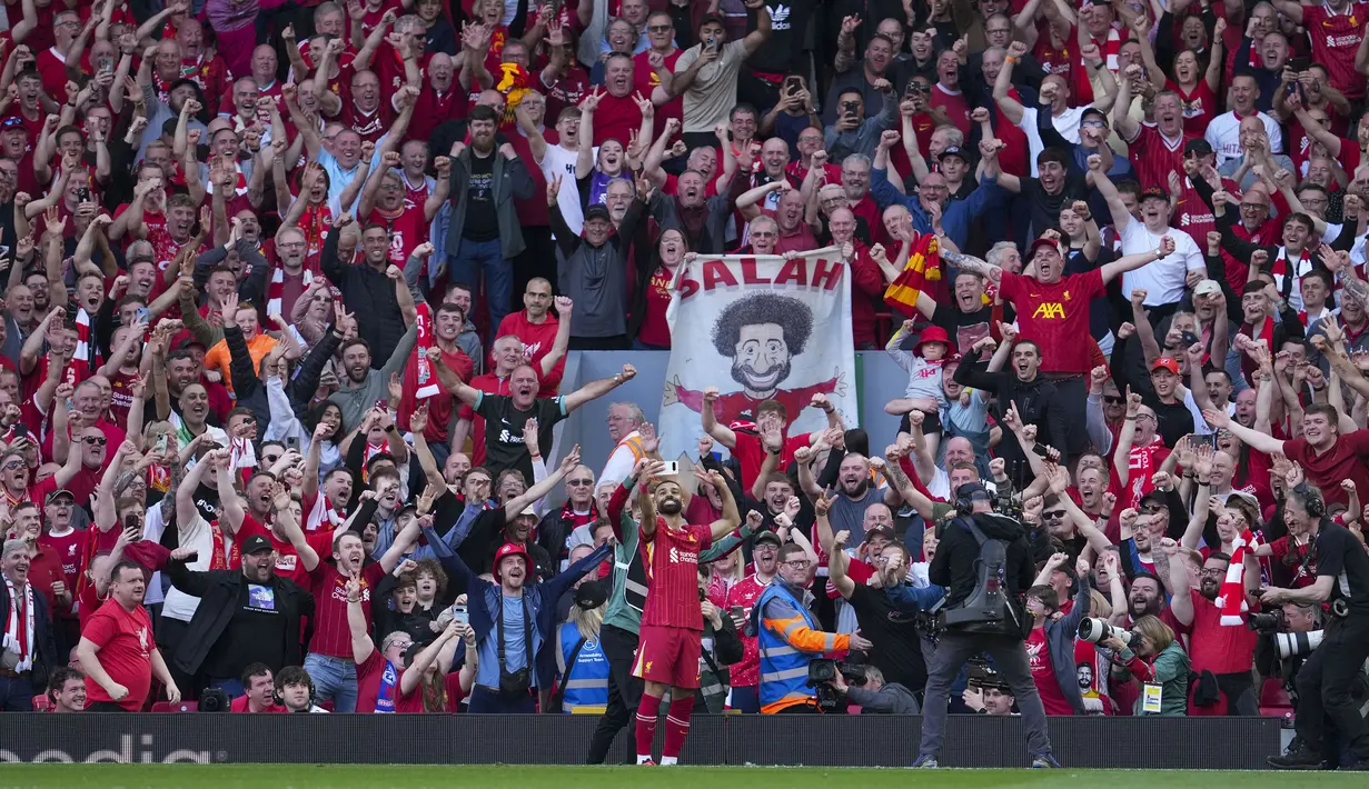 Pemain Liverpool, Mohamed Salah merayakan golnya dengan berswafoto bersama para pendukung timnya dalam laga lanjutan Liga Inggris 2024/2025 melawan Tottenham Hotspur di Anfiled, Liverpool, Inggris, Minggu (27/04/2025) waktu setempat. (AP Photo/Jon Super)