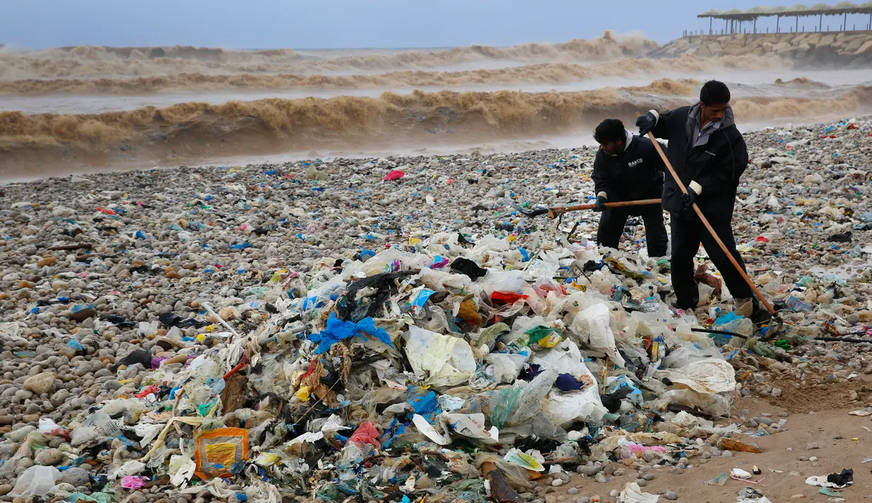 Pekerja membersihkan tumpukan sampah yang menutupi pantai Zouq Mosbeh di utara Beirut, 22 Januari 2018. Lautan sampah itu menumpuk setelah disapu gelombang besar yang ditimbulkan oleh hantaman badai di Lebanon akhir pekan lalu. (AP/Hussein Malla)