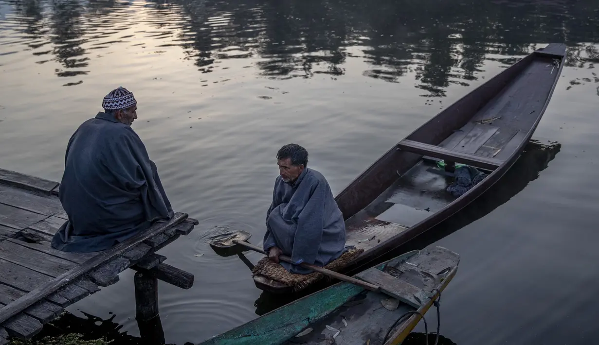 Orang-orang Kashmir mengobrol di pagi hari di dermaga di Danau Dal di Srinagar, Kashmir yang dikendalikan India (18/10/2020). (AP Photo/Dar Yasin)