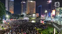 Ribuan pengunjung padati kawasan Bundaran HI, Jakarta, untuk merayakan pergantian tahun 2023, Sabtu (31/12/2022). Ribuan pengunjung memadati kawasan Bundaran HI yang menjadi pusat acara pesta kembang api di car free night Jalan Sudirman-Thamrin. (Liputan6.com/Angga Yuniar)