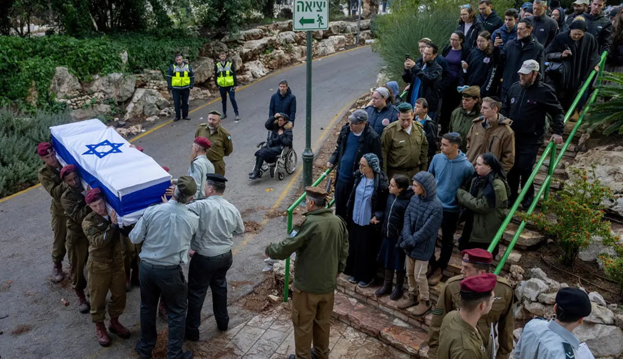 Tentara Israel membawa peti mati Sersan Binyamin Meir Airly yang terbungkus bendera saat pemakamannya di pemakaman militer Gunung Herzl, Yerusalem, Minggu (19/11/2023). Airly terbunuh dalam operasi darat militer di Jalur Gaza. (AP Photo/Ohad Zwigenberg)