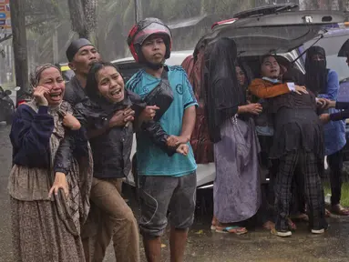 Keluarga korban menangis histeris saat jenazah diambil dari reruntuhan bangunan di daerah yang terkena gempa bumi di Mamuju, Sulawesi Barat, Jumat (15/1/2021). Gempa bermagnitudo 6,2 mengguncang Mamuju, Sulawesi Barat. (AP Photo/Yusuf Wahil)