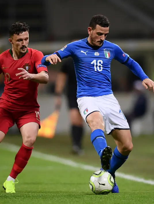 Gelandang Italia,  Alessandro Florenzi mengontrol bola dari kawalan pemain Portugal, Mario Rui selama pertandingan UEFA Nations League di Stadion San Siro di Milan (17/11). Portugal berhasil lolos ke semifinal. (AFP Photo/Marco Bertorello)