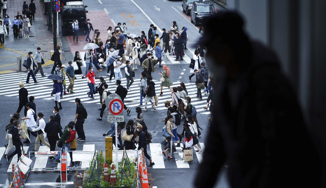 Seorang pria melihat keluar melalui jendela pada awal liburan "Minggu Emas" Jepang di distrik Shibuya, Tokyo (29/4/2021). Periode Golden Week bergantung pada tahunnya, tapi dimulai sekitar 29 April dan berakhir sekitar 5 Mei. (AP Photo/Eugene Hoshiko)