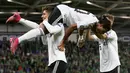 Pemain tengah Jerman, Serge Gnabry (tengah) merayakan golnya ke gawang Irlandia Utara saat bertanding dalam kualifikasi Euro 2020 di Windsor Park, Belfast, Senin (9/9/2019). Jerman berhasil merebut puncak klasemen grup C kualifikasi Euro 2020 usai mengalahkan Irlandia Utara 2-0. (Paul Faith/AFP)