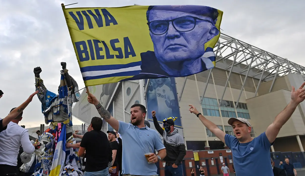 Suporter Leeds United merayakan keberhasilan timnya yang sukses kembali ke kompetisi Premier League di Elland Road, Leeds, Sabtu (18/7/2020). Leeds United dipastikan promosi ke Premier League musim 2020/2021 usai West Brom kalah 1-2 atas Huddersfield Town. (AFP/Paul Ellis)