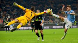Kiper Inter milan, Samir Handanovic (kiri) berebut bola dengan pemain Lazio, Ciro Immobile pada laga lanjutan Liga Italia 2021/2022 di Giuseppe Meazza, Milan, 9 Januari 2022. (AFP/Miguel Medina)