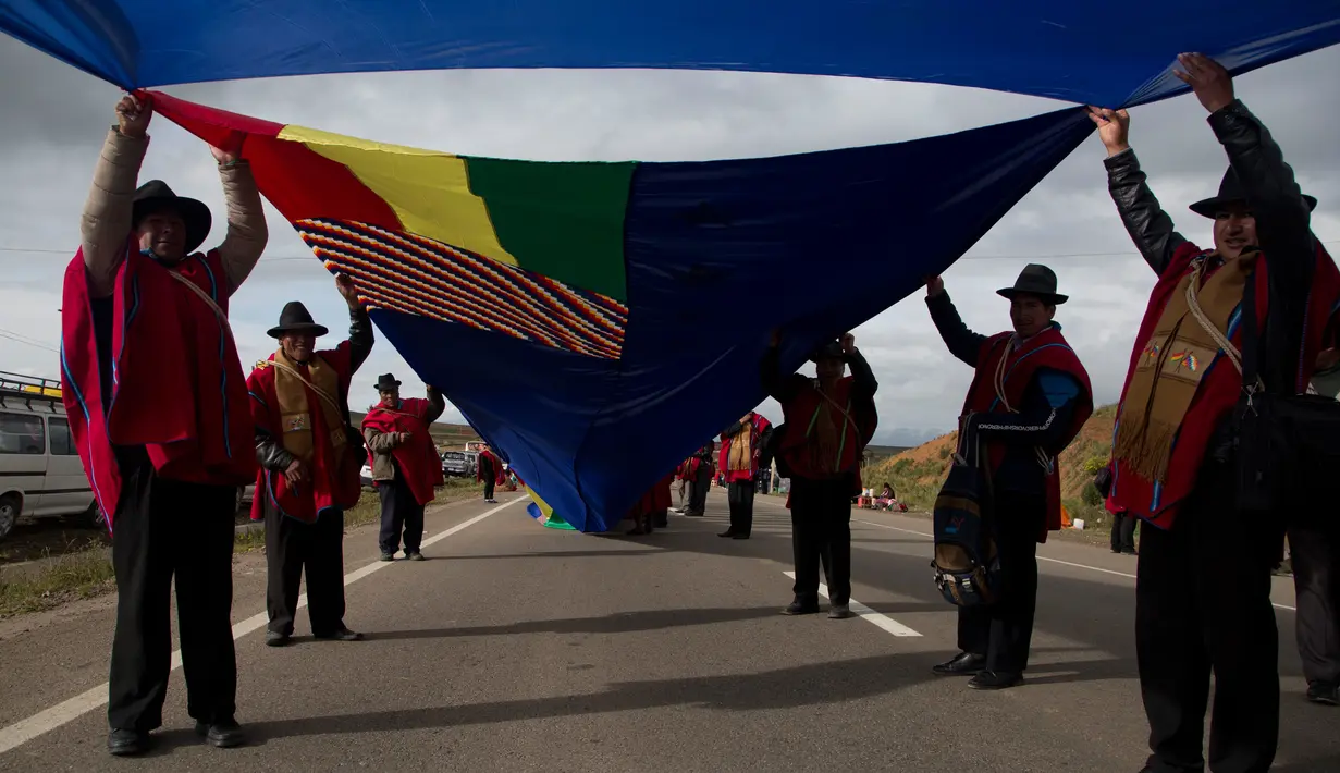 Pasukan Aymara memegang bendara angkatan laut Bolivia di jalan raya antara Oruro dan La Paz Bolivia (10/3). Sebuah bendera yang dominan berwarna biru di bentangkan sejauh 150 mil atau 200 kilometer. (AP Photo / Juan Karita)