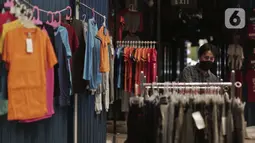 Seorang pria melihat-lihat pakaian di Pasar Cipulir, Jakarta, Senin (6/4/2020). Sebelum pandemi virus corona COVID-19, penjualan pakaian dan pengiriman paket ke daerah setiap mendekati bulan Ramadan seperti ini akan melonjak. (Liputan6.com/Johan Tallo)