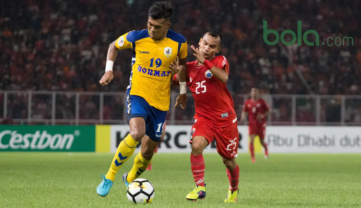 Pemain Persija Jakarta, Riko Simanjuntak berebut bola dengan pemain Tampines Roversdi Lapangan Utama Gelora Bung Karna, Jakarta, Rabu (28/2/2018). Persija Jakarta menang 4-1 atas Tampines Rovers pada AFC Cup grup H. (Bola.com/Asprilla Dwi Adha)