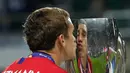 Gelandang Atletico Madrid, Antoine Griezmann mencium Piala Super Eropa usai pertandingan melewan Real Madrid di Lillekula Stadium, Tallinn, Estonia, (15/8). Atletico Madrid berhasil mengalahkan Real Madrid dengan skor telak 4-2. (AP Photo/Pavel Golovkin)