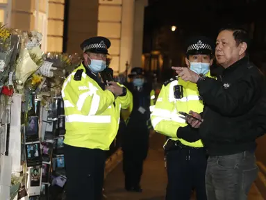 Duta Besar Myanmar untuk Inggris, Kyaw Zwar Minn berbicara dengan polisi di luar gedung Kedutaan Besar Myanmar di London, Rabu (7/4/2021). Kyaw Zwar Minn mengatakan pihak yang terkait dengan militer Yangon telah "menduduki" kedutaannya di London. (AP Photo/Alastair Grant)