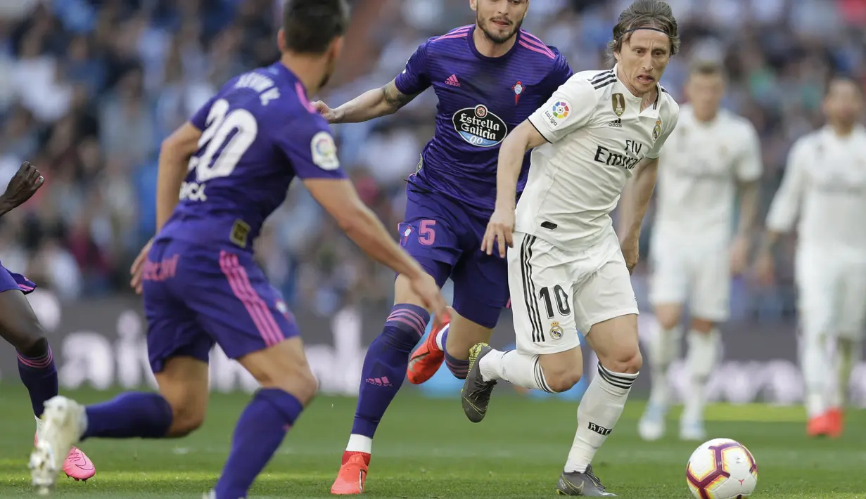Gelandang Real Madrid, Luka Modric, berusaha melewati pemain Celta Vigo pada laga La Liga 2019 di Stadion Santiago Bernabeu, Sabtu (16/3). Real Madrid menang 2-0 atas Celta Vigo. (AP/Paul White)