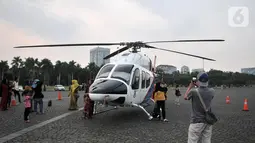 Warga berfoto dengan helikopter Polri yang terparkir di kawasan Monas, Jakarta, Rabu (16/10/2019). Kehadiran empat helikopter TNI/Polri yang akan digunakan dalam apel pengamanan pelantikan presiden dan wakil presiden tersebut menarik perhatian pengunjung Monas. (merdeka.com/Iqbal Nugroho)