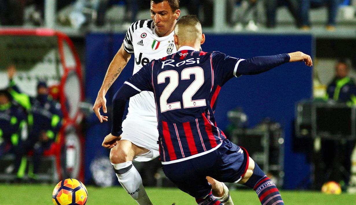 Striker Juventus, Mario Mandzukic, berusaha melewati pemain Crotone, Aleandro Rosi. Meski berstatus tamu, Juve lebih menguasai jalannya laga dengan penguasaan bola mencapai 76 persen. (EPA/Albano Angilletta)