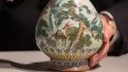 Sebuah vas China antik yang diyakini berasal dari masa Dinasti Qing pada abad ke-18 diperlihatkan di rumah lelang Sotheby, Paris, Selasa (22/5). Vas tersebut lama tersimpan di dalam sebuah kotak sepatu milik satu keluarga di Perancis. (AFP/Thomas SAMSON)