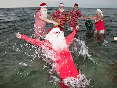 Sinterklas dari penjuru dunia menikmati bermain air laut Klampenborg di luar Kopenhagen, Denmark, Selasa (25/7). Lima bulan menjelang natal, ratusan Sinterklas berkumpul dalam Kongres Dunia Sinterklas yang ke 60. (Tobias Nicolai / Ritzau Foto via AP)