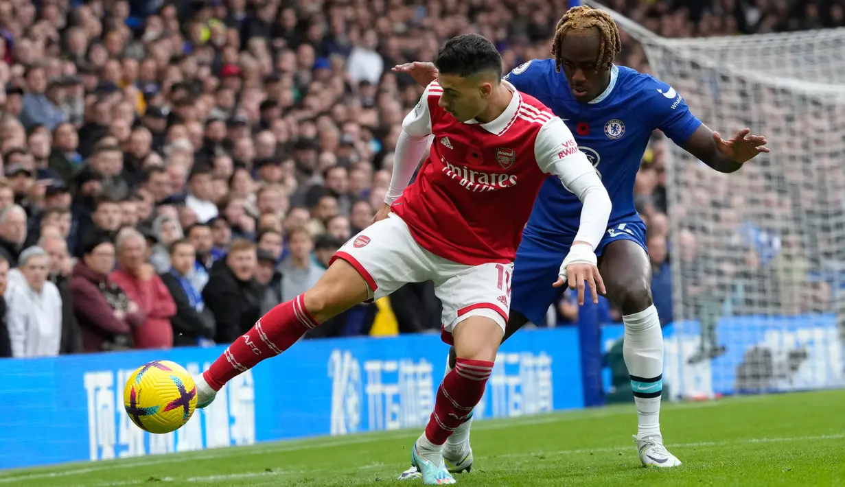Pemain Arsenal Gabriel Martinelli (kiri) berebut bola dengan pemain Chelsea Trevoh Chalobah pada pertandingan sepak bola Liga Inggris di Stadion Stamford Bridge, London, Inggris, 6 November 2022. Arsenal kembali memuncaki klasemen Liga Inggris usai mengalahkan Chelsea dengan skor 1-0. (AP Photo/Kirsty Wigglesworth)