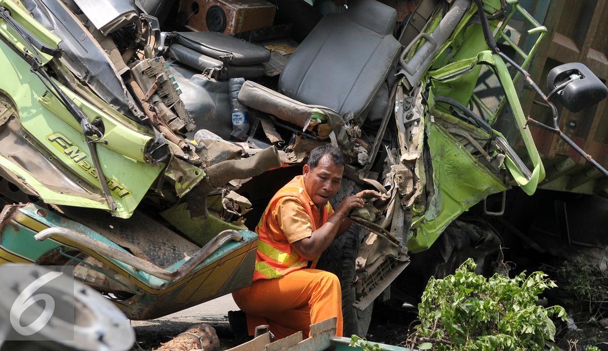 Petugas mengevakuasi truk ringsek yang menabrak tiang rambu petunjuk arah di Jalan Tol Jakarta-Tangerang, Jakarta, Senin (5/9). Truk bernomor polisi B 935 IC menabrak tiang rambu lalu lintas di kilometer 6,5. (Liputan6.com/Yoppy Renato)