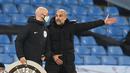 Pelatih Manchester City, Pep Guardiola, berbicara kepada ofisial wasit saat pertandingan melawan West Brom pada laga lanjutan Liga Inggris di Etihad Stadium, Rabu (16/12/2020). Pep Guardiola melakukan protes karena durasi injury time yang dianggap sedikit. (AFP/Clive Brunskill/pool)