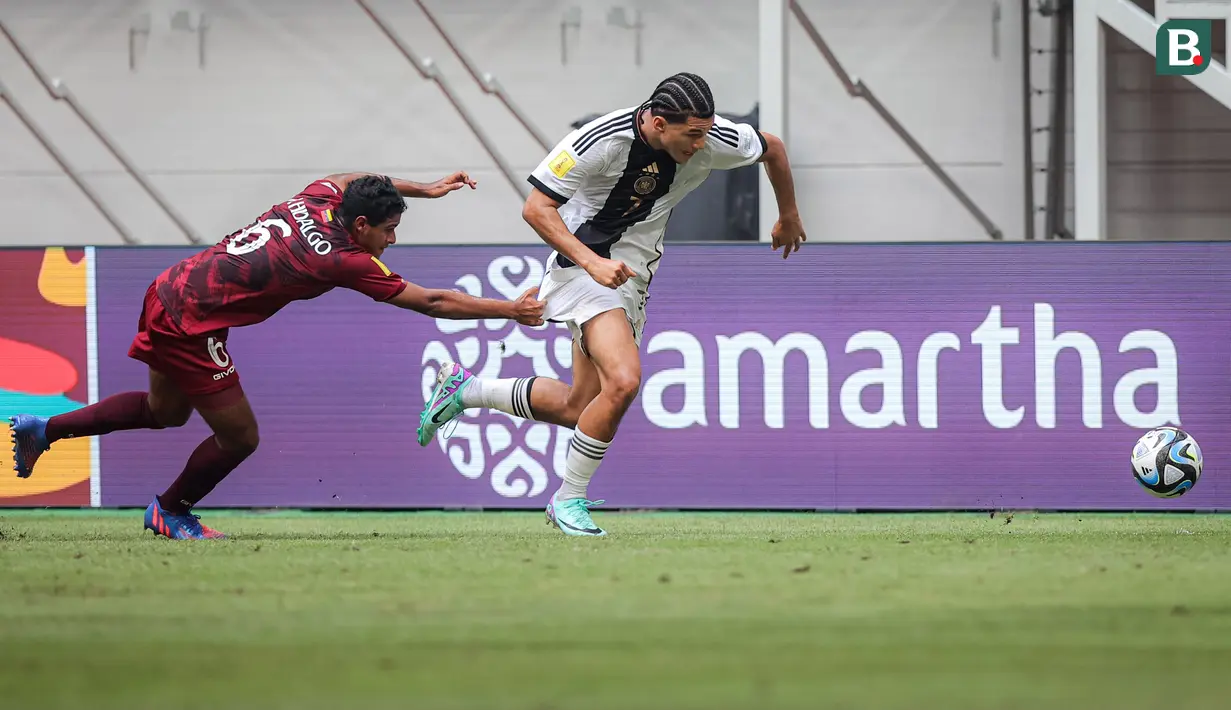 <p>Pemain Timnas Jerman U-17, Paris Brunner (kanan)&nbsp;mendaptkan gangguan dari&nbsp;pemain Timnas Venezuela U-17, Rai Hidalgo dalam laga pamungkas Grup F Piala Dunia U-17 2023 yang berlangsung di Jakarta International Stadium (JIS), Jakarta, Sabtu (18/11/2023). (Bola.com/Bagaskara Lazuardi)</p>