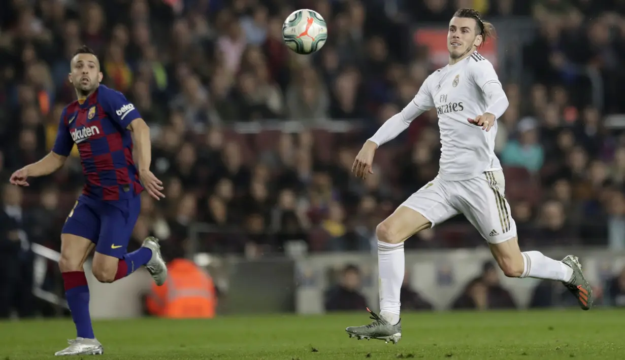Penyerang Real Madrid, Gareth Bale dan bek Barcelona Jordi Alba mengejar bola pada pertandingan lanjutan La Liga Spanyol di stadion Camp Nou (18/12/2019). Barcelona bermain imbang 0-0 atas Real Madrid. (AP Photo/Bernat Armangue)