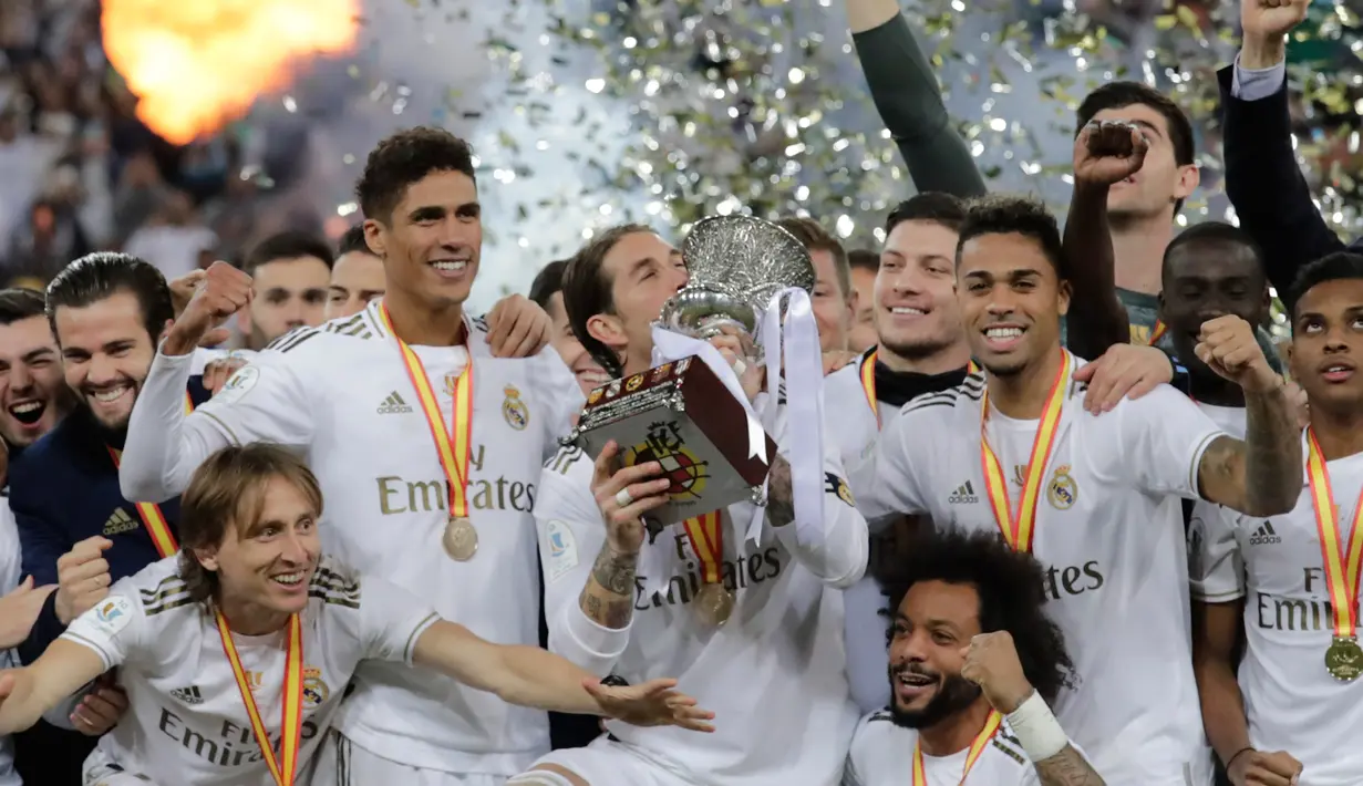 Pemain Real Madrid Sergio Ramos (tengah) mencium trofi juara Piala Super Spanyol bersama rekan-reakannya usai mengalahkan Atletico Madrid pada pertandingan final di King Abdullah Stadium, Jeddah, Arab Saudi, Senin (13/1/2020). Real Madrid menang adu penalti 4-1. (AP Photo/Hassan Ammar)