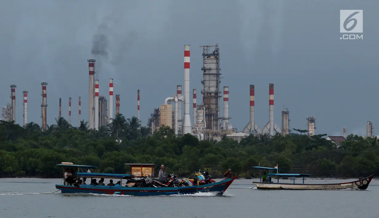Perahu kayu membawa muatan melintas di dekat kilang minyak Pertamina Refenery Unit IV Cilacap, Rabu (7/2). Kilang Pertamina RU IV Cilacap merupakan satu dari enam unit pengolahan minyak milik PT. Pertamina di Indonesia. (Liputan6.com/JohanTallo)