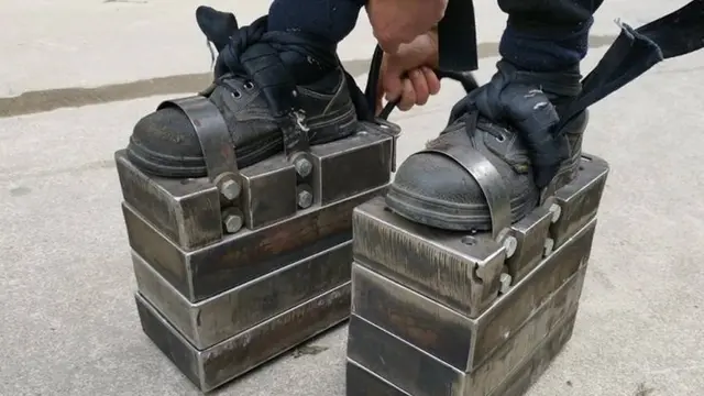 Seorang pria berkepala 5 berjalan pakai sepatu berpelat baja seberat 150 kg.
