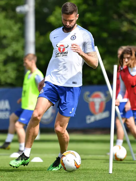 Striker Chelsea, Olivier Giroud menggiring bola saat mengikuti latihan tim di Chelsea Training Ground, di Cobham, Surrey (22/5/2019). Chelsea akan bertanding melawan Arsenal pada babak Final Liga Europa pada 29  Mei di Baki Olimpiya Stadionu. (AFP Photo/Ben Stansall)