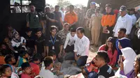 Presiden Joko Widodo atau Jokowi bersama Gubernur NTB Tuan Guru Bajang (TGB) Zainul Majdi berbincang anak-anak saat mengunjungi korban gempa di Desa Madayin, Sambelia, Lombok Timur, NTB, Senin (30/7). (Agus Suparto/Indonesian Presidential Palace/AFP)