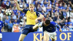 Pemain depan Leicester City, David Nugent (kanan), mencium sepatu bek Arsenal, Per Mertesacker, di laga lanjutan Liga Primer Inggris 2014-2015 di Stadion King Power, (31/8/2014). (REUTERS/Dylan Martinez)