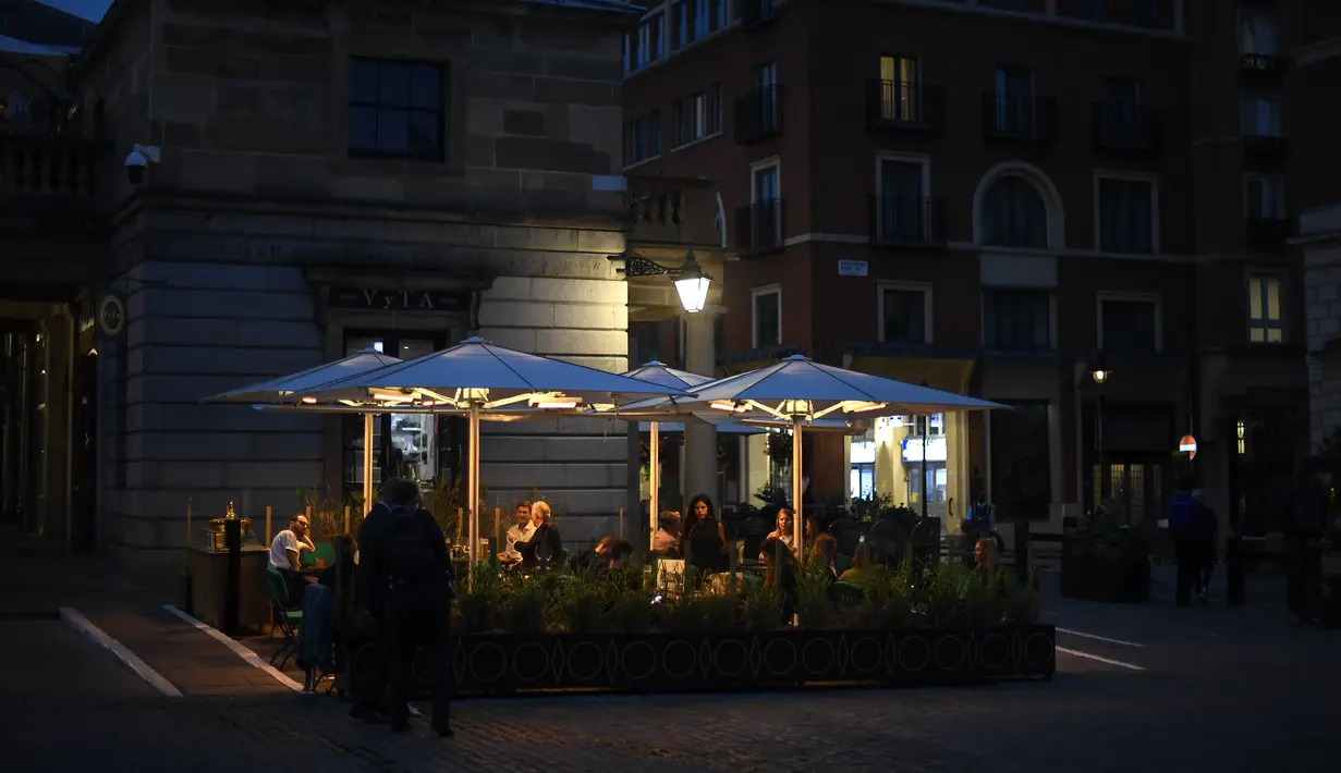 Orang-orang makan dan minum di Covent Garden, di London, Selasa (22/9/2020). Perdana Menteri Inggris, Boris Johnson, telah mengumumkan bahwa pub dan restoran tutup pada pukul 10 malam, karena lonjakan kasus virus corona di seluruh Inggris. (AP Photo / Alberto Pezzali)