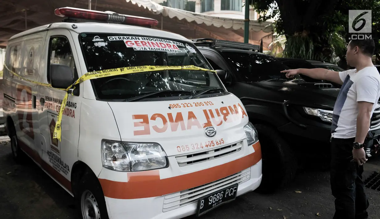 Seorang pria menunjuk ambulans Partai Gerindra yang terparkir di halaman Mapolda Metro Jaya, Jakarta, Kamis (23/5/2019). Ambulans milik Partai Gerindra Tasikmalaya berpelat nomor B 9686 PCF tersebut diamankan polisi karena diduga mengangkut batu dalam Aksi 22 Mei. (merdeka.com/Iqbal Nugroho)