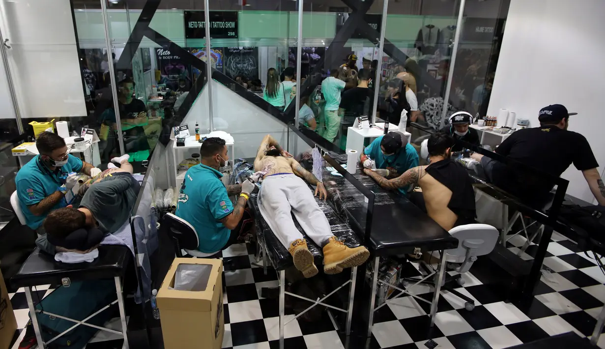 Sejumlah seniman saat membuat tato para pengunjung di Tattoo Week SP 2016 di Sao Paulo, Brasil, (23/7). (REUTERS/Paulo Whitaker)