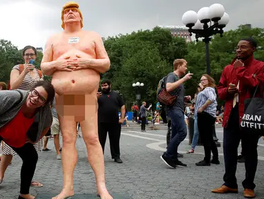 Warga AS foto bersama dengan patung Donald Trump tanpa busana di Union Square Park, New York, AS, Kamis (18/8). Patung Capres AS dari Partai Republik ini juga dipajang di San Francisco, Los Angeles, Cleveland, dan Seattle. (REUTERS/Brendan McDermid)