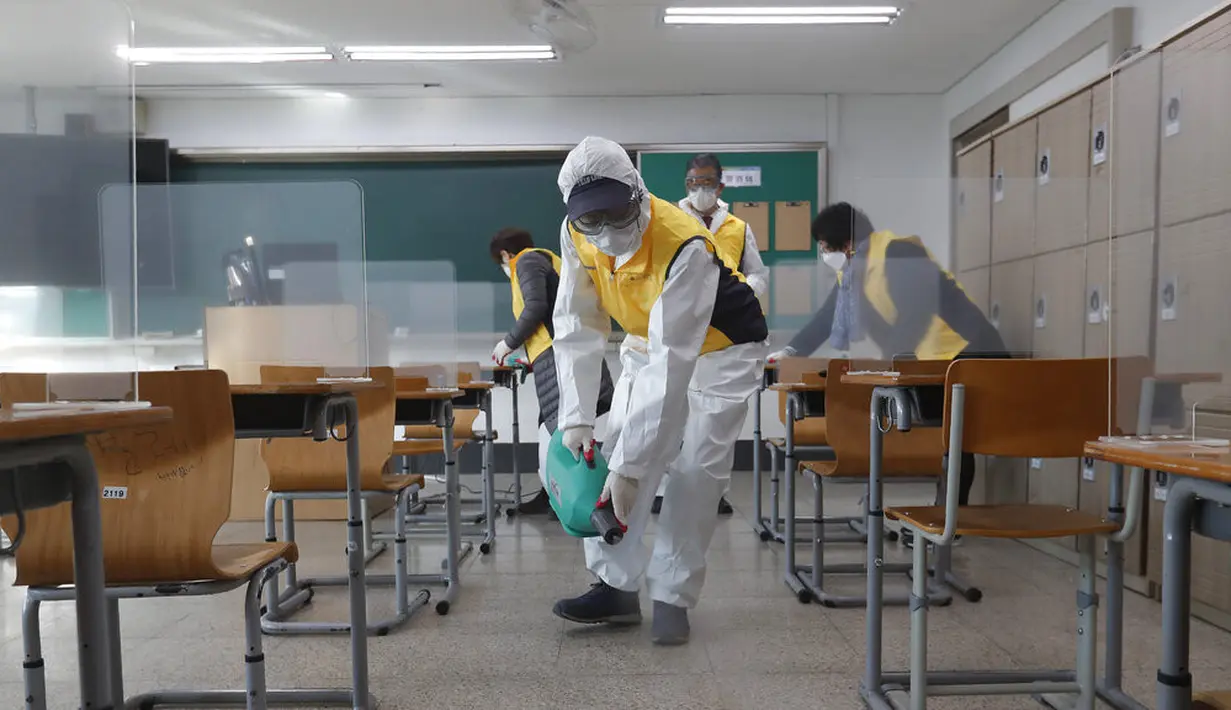 Petugas kesehatan mendisinfeksi ruang kelas untuk ujian masuk perguruan tinggi di Seoul, Korea Selatan, Selasa (1/12/2020). Sekitar 490.000 siswa lulusan sekolah menengah atas di Korea Selatan akan menjalani Tes Kemampuan Skolastik Perguruan Tinggi pada 3 Desember 2020. (AP Photo/Ahn Young-joon)