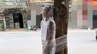 Seorang lelaki di Hanoi diikat dipohon dan dibungkus plastik karena tak bayar usai ditato (dok.phapluatvacuocsong.vn)