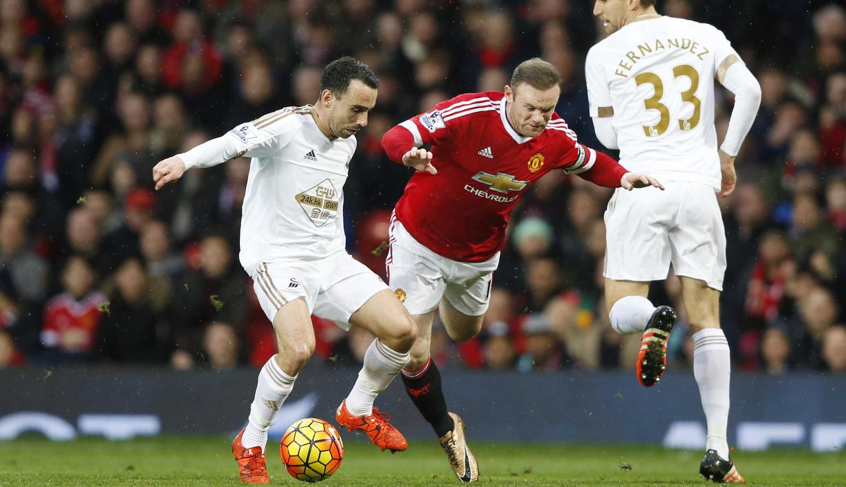 Pemain Manchester United,  Wayne Rooney  mencoba melewati dua pemain Swansea City pada lanjutan Liga Premier Inggris di Stadion Old Trafford, Sabtu (02/01/2016). Manchester United menang 2-1. (Reuters/Carl Recine)